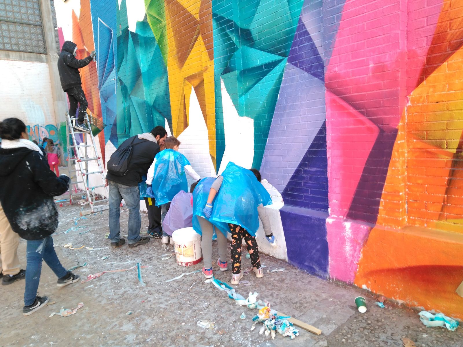 Familias pintando el muro del patio