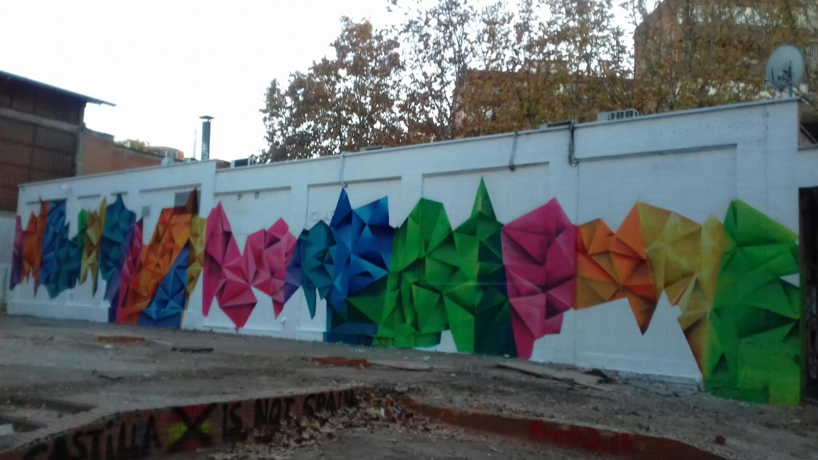 Muro del patio pintado con formas de colores